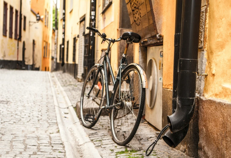 a bicycle leans up against a wall next to an open door