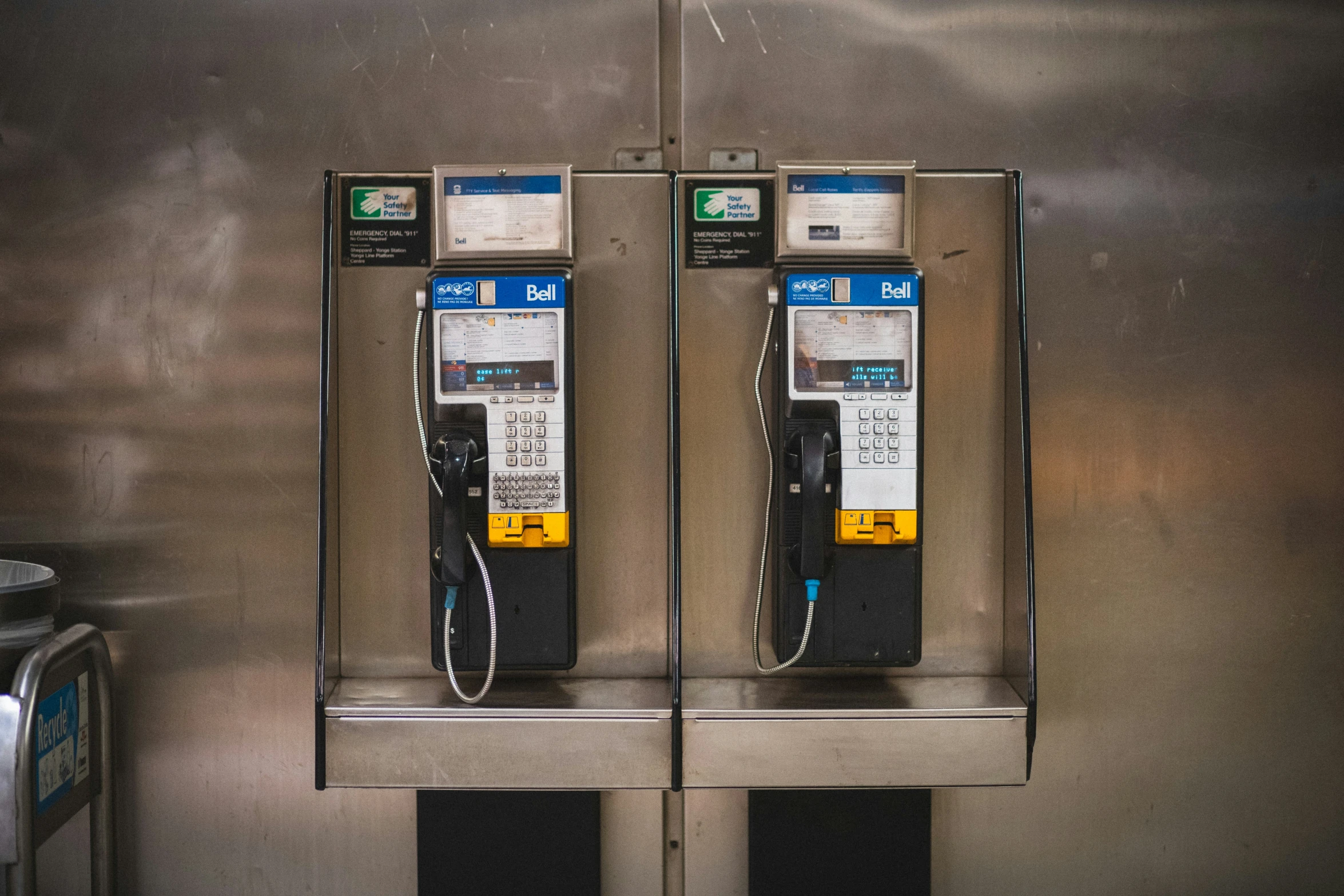 two machines sitting next to each other on top of a metal wall