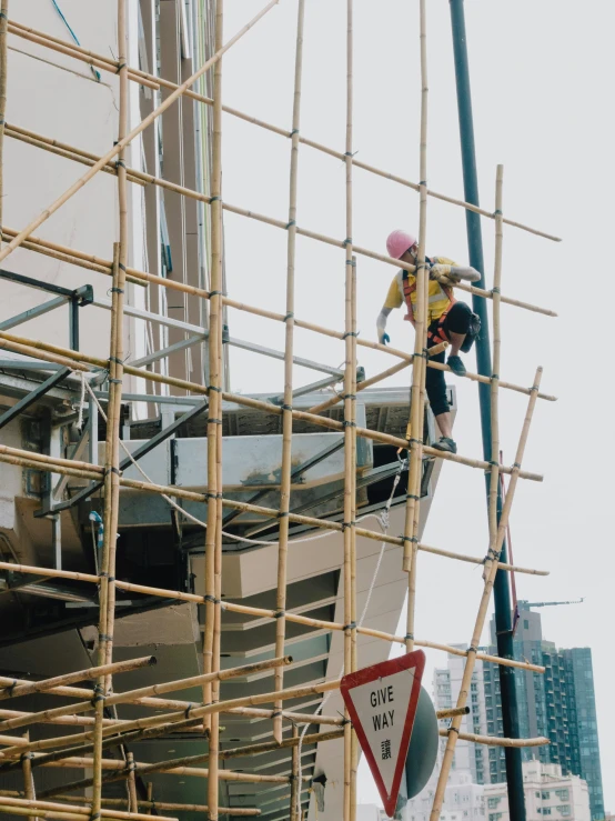 construction worker at the top of a scaffold working on a building