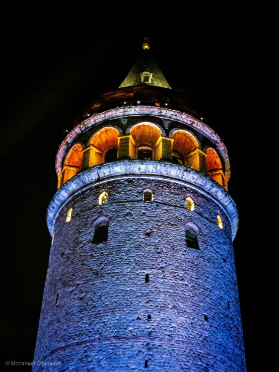 a very tall tower lit up with lights at night