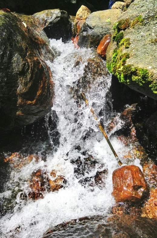 there are rocks and water next to the rushing water