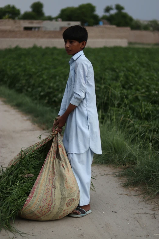 the boy with the big bag of grass