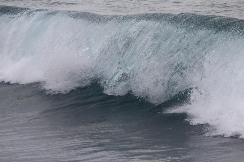 a big wave crashing into the beach on it's way to shore