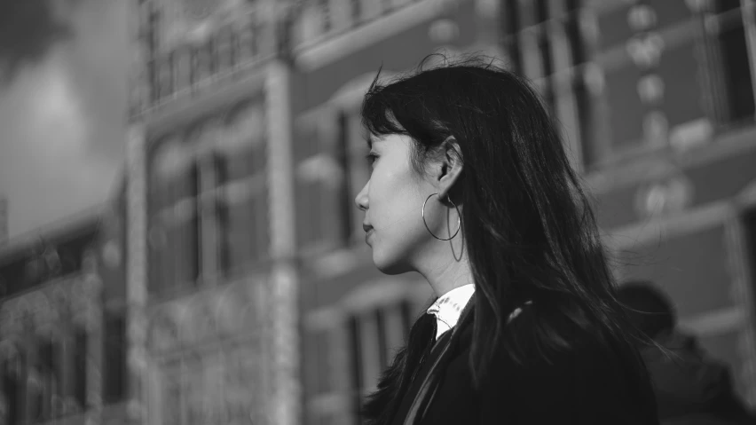 a black and white po of a woman near an apartment building