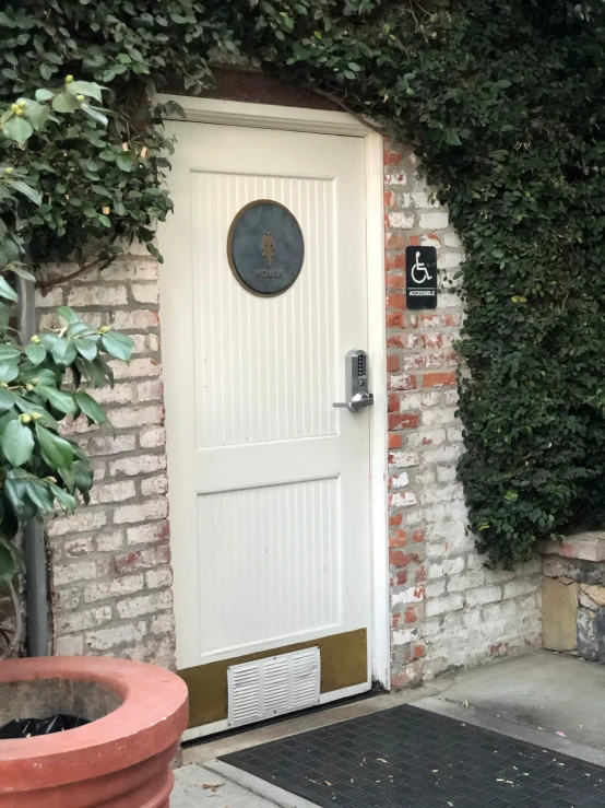 a house has an attached garden area with a potted plant and decorative doormat