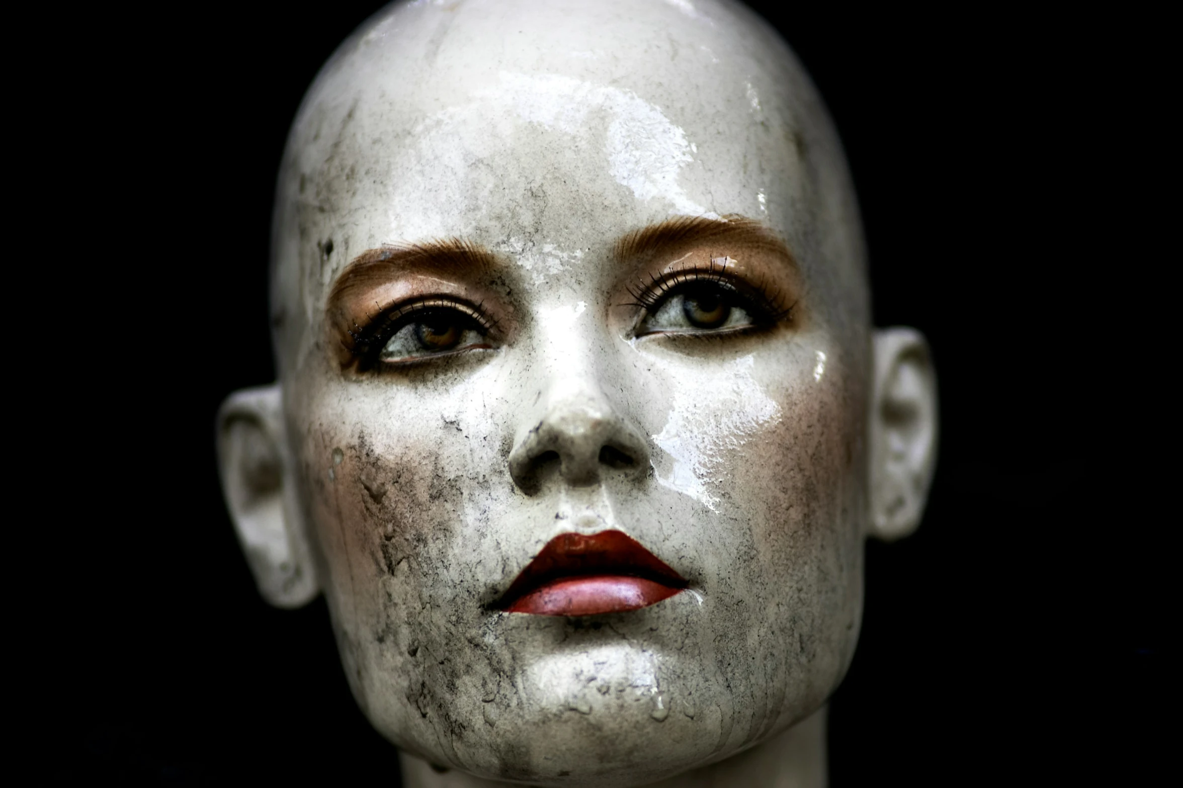 a creepy creepy looking mannequin with painted eyes and white makeup