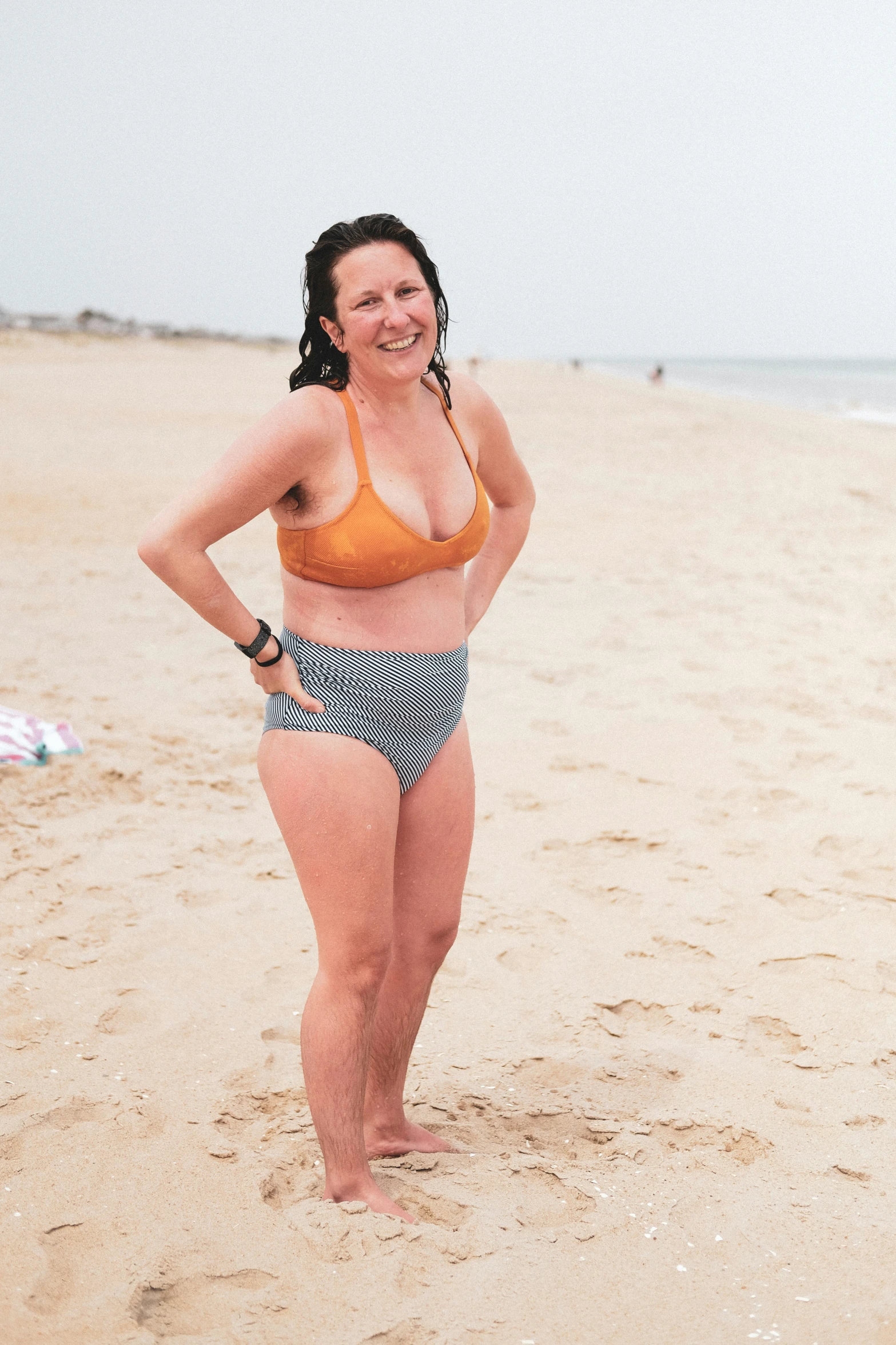 a woman in yellow bikini standing on the beach