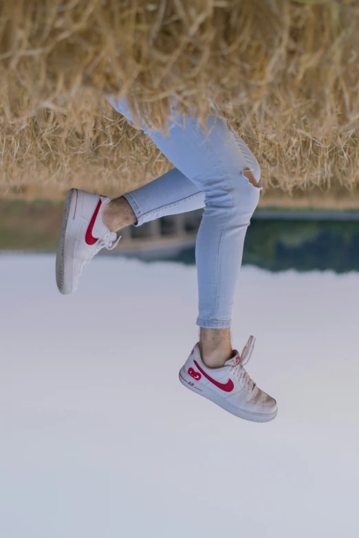 a person jumping high into the air above hay