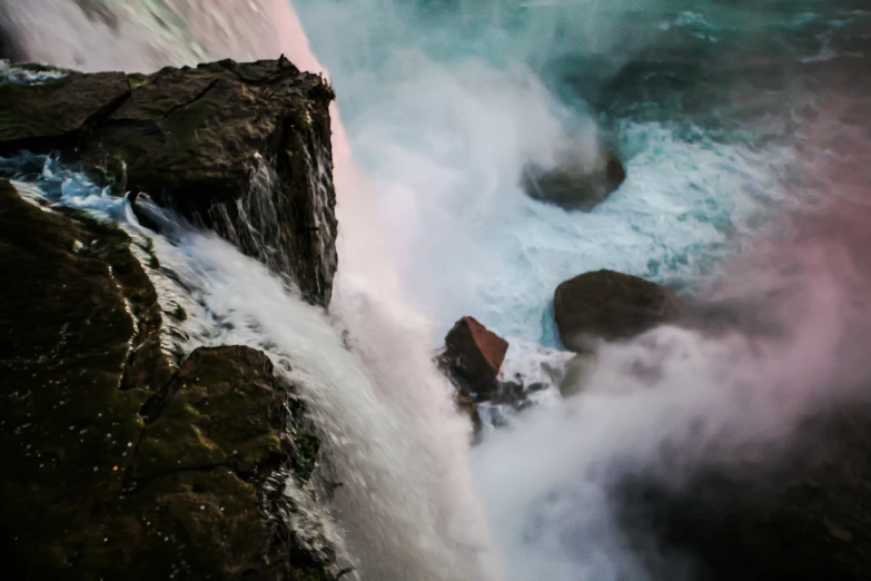 water falls over the rocks in front of a rock