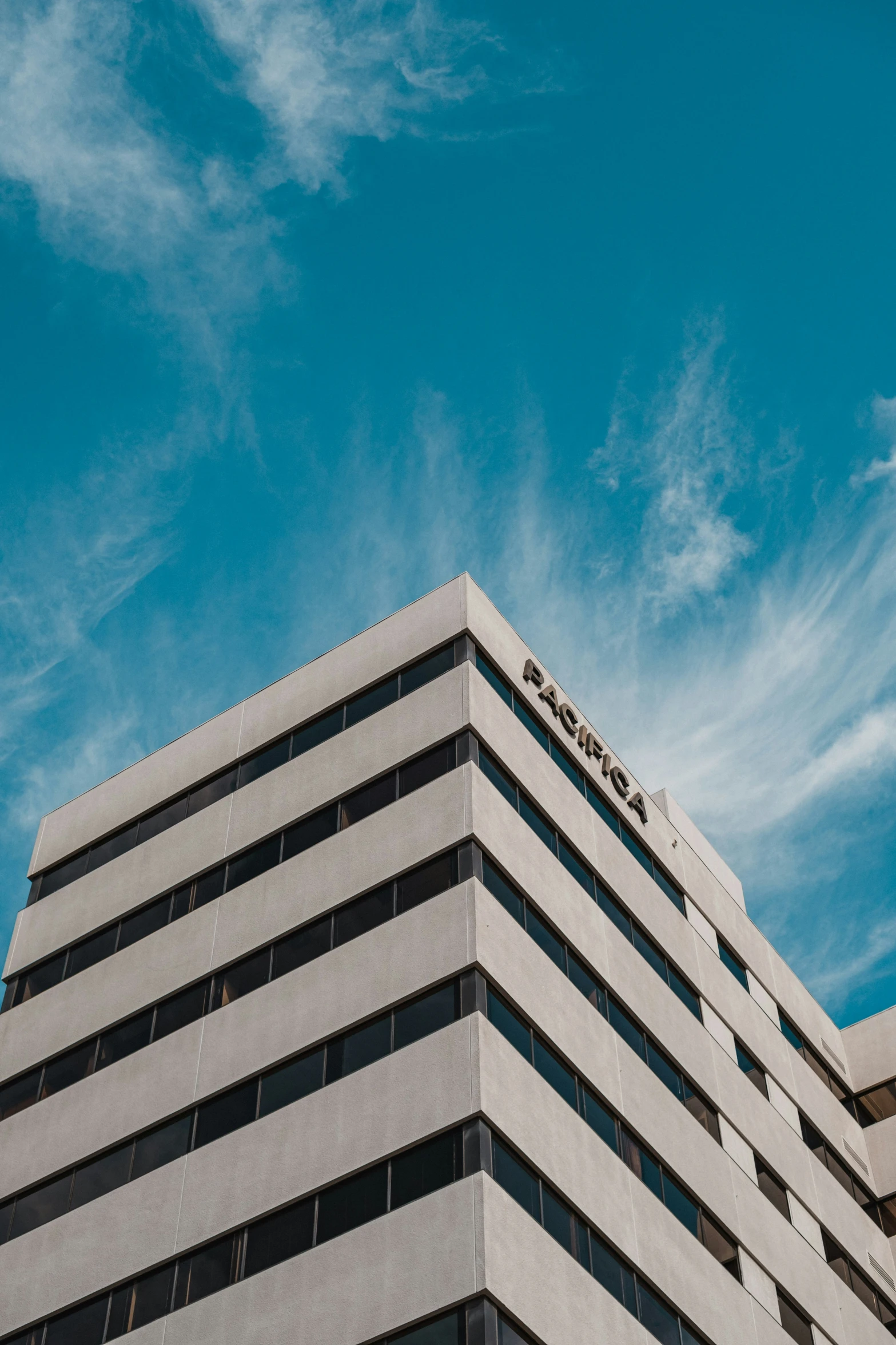 a tall building sitting under a cloud filled sky