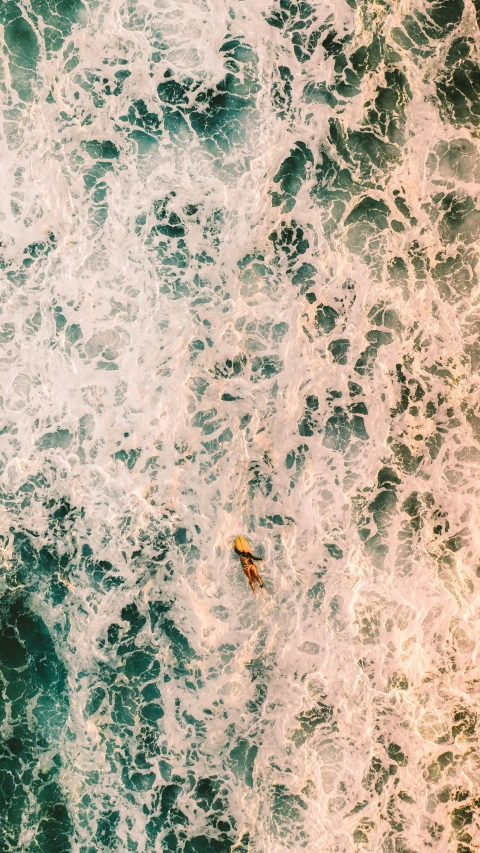 an aerial view of the top of a surfer riding a wave