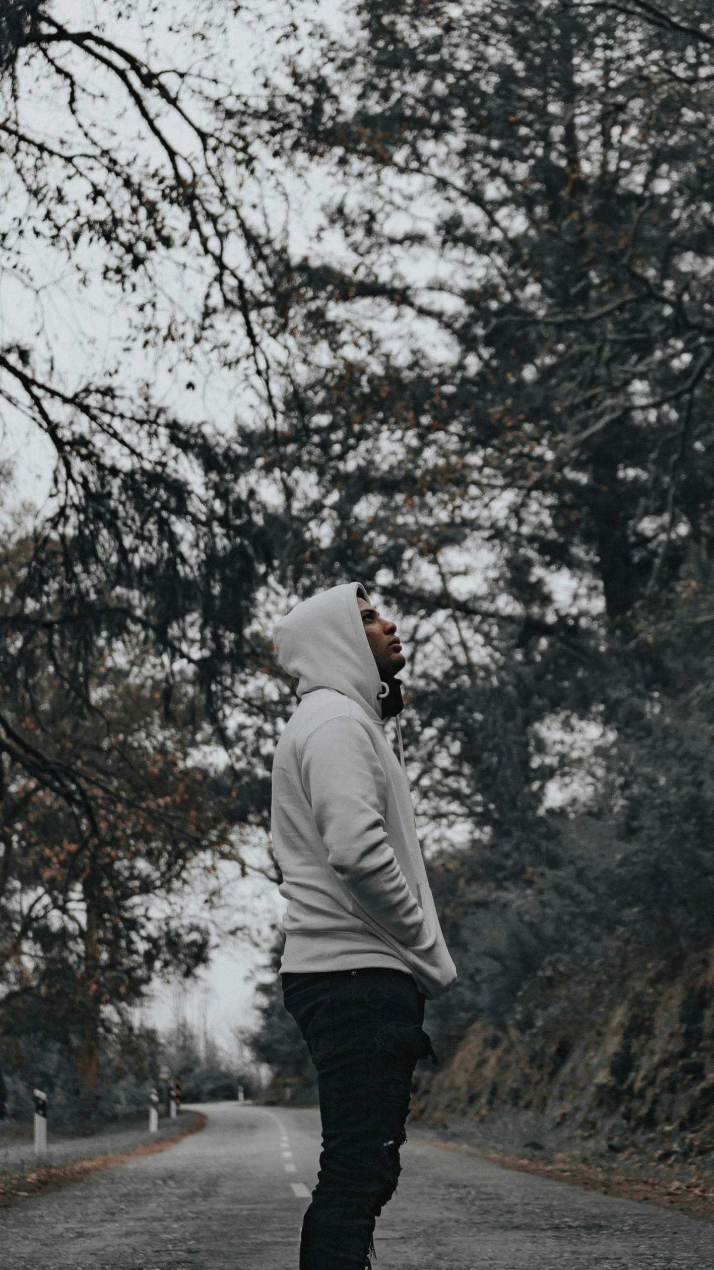 a person walking down a road while holding a phone