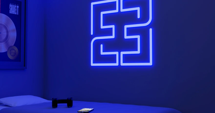 a dimly lit room with a large neon s on the wall
