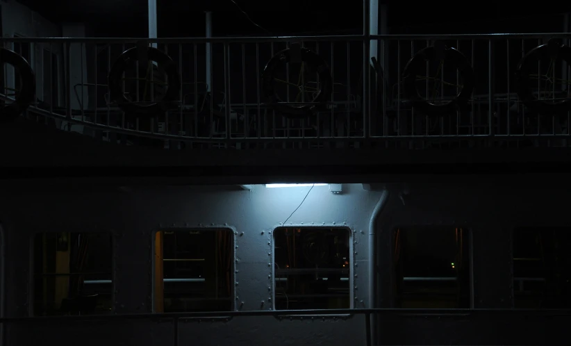 a balcony at night with bicycles parked at the railing