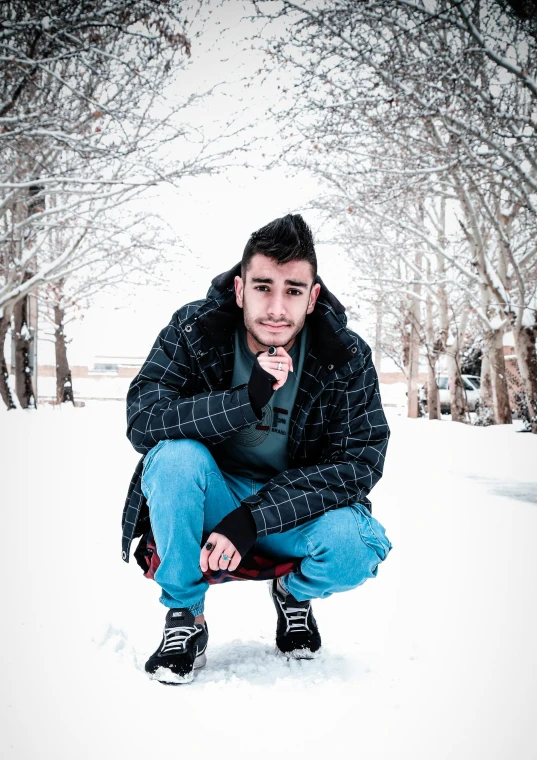 a man in the snow with a jacket and jeans