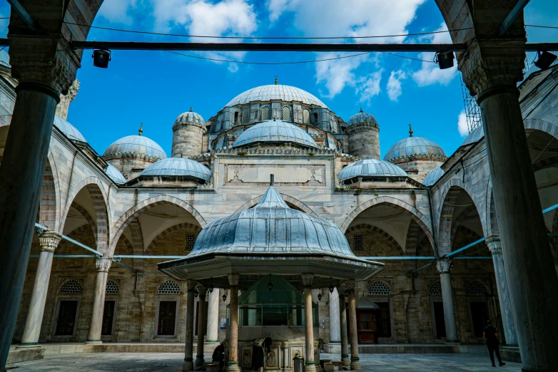 some people stand around a building with many arches