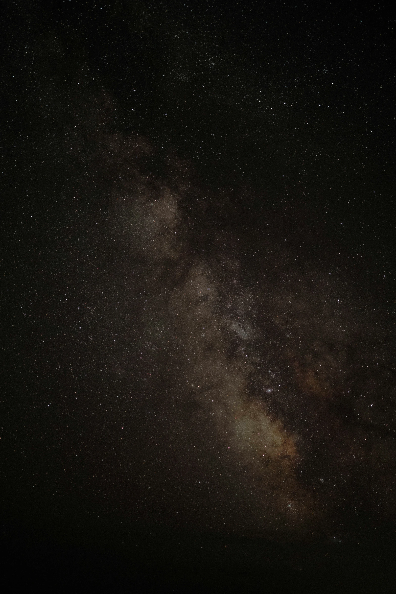 the night sky has stars above a body of water