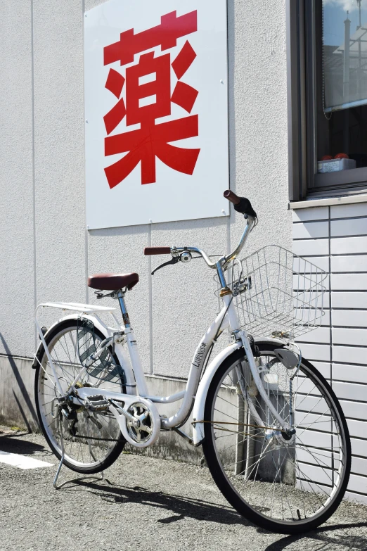 a white bike leaning up against the side of a wall