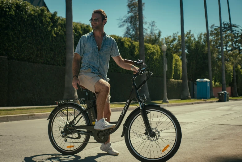 man riding on back of bike on road near trees