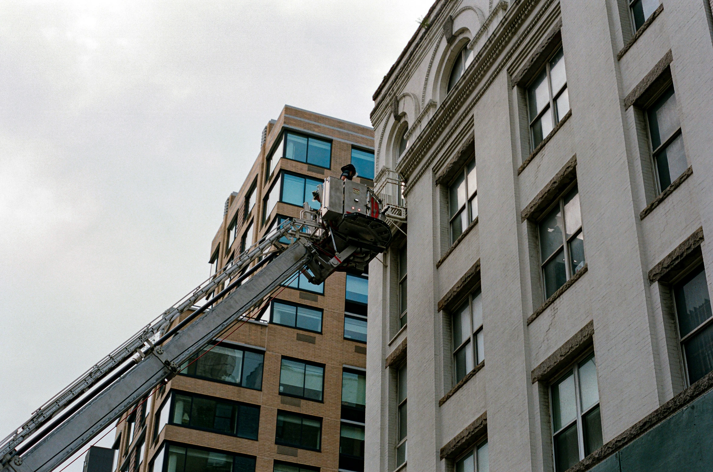 a man on a crane up to some windows