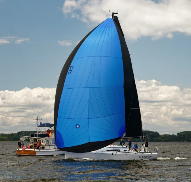 a sailboat with blue sails in the water