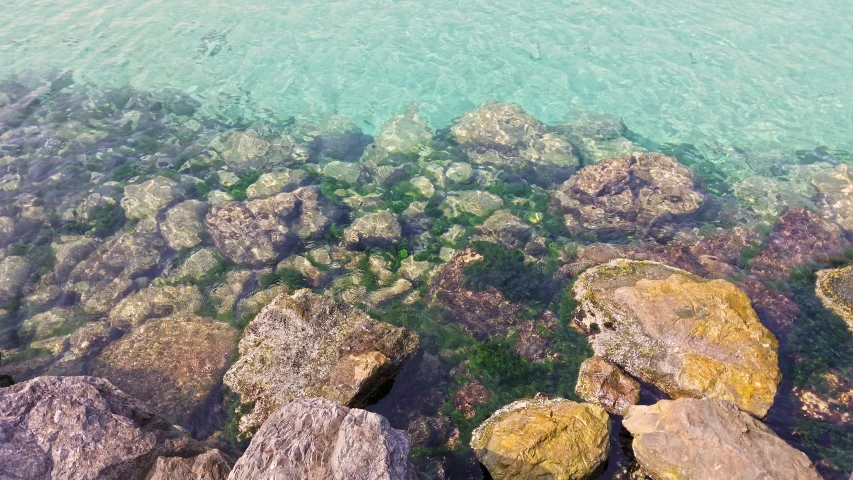 a body of water surrounded by rocks next to shore