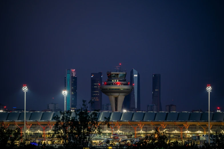 a skyline at night with lights on and a tower with lights