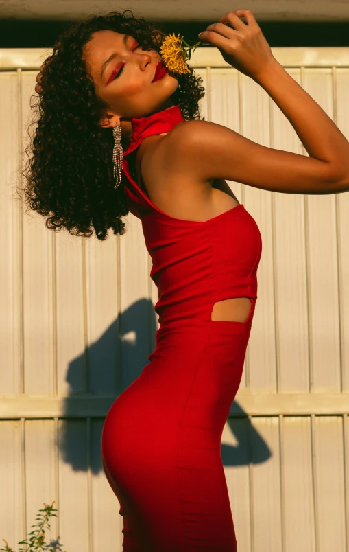 the beautiful young woman in red dress has a flower in her hair