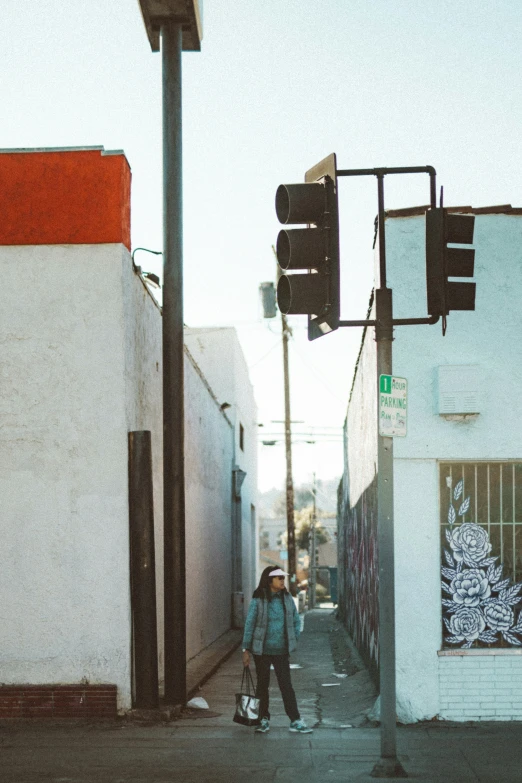 a woman walks down a street with her back turned