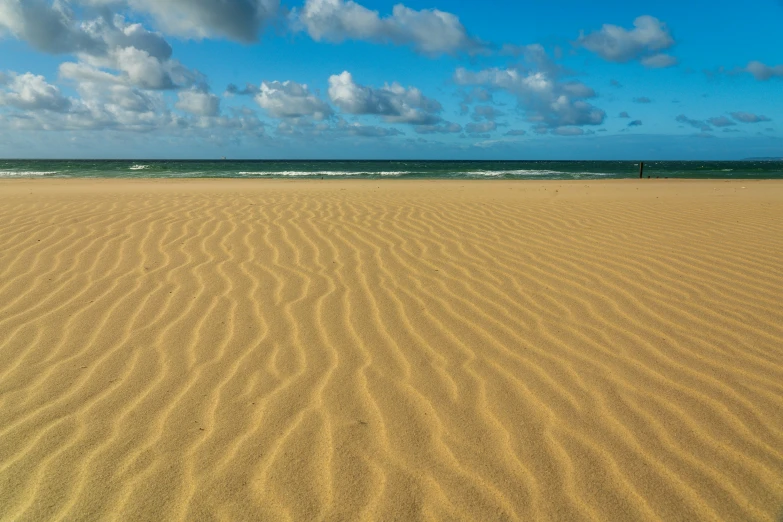 the yellow sand in front of a clear blue sky