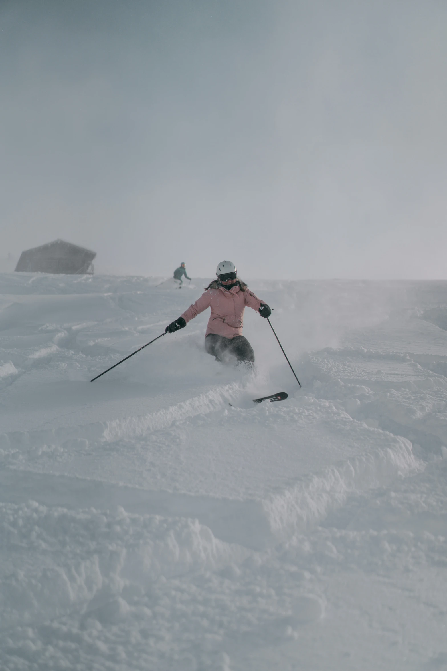 a skier is skiing on snow and there are two rocks in the background