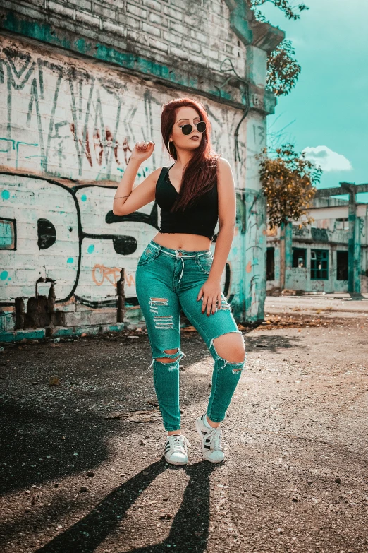 a young woman wearing green ripped jeans and sneakers