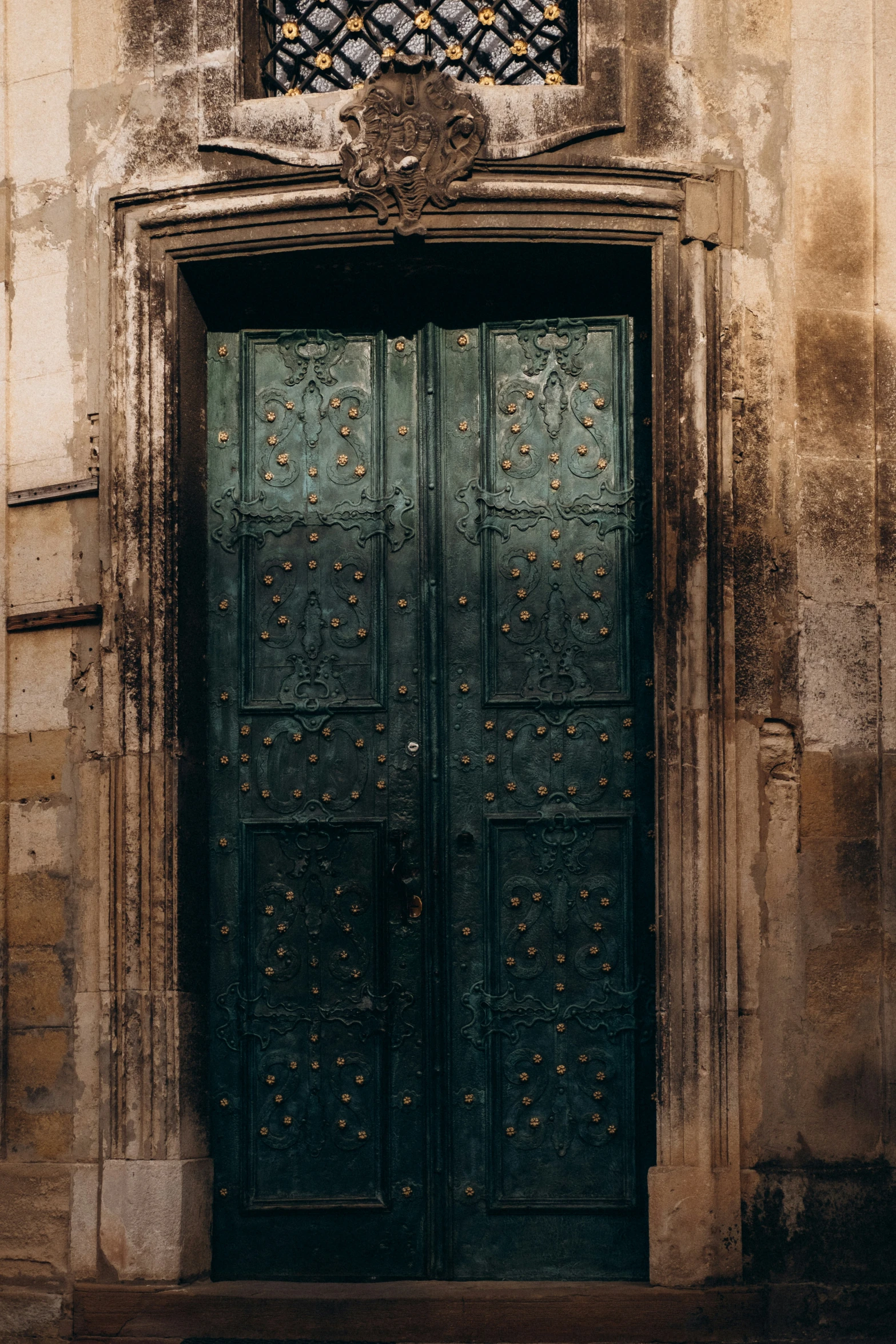 a tall wooden door with many small studded pieces