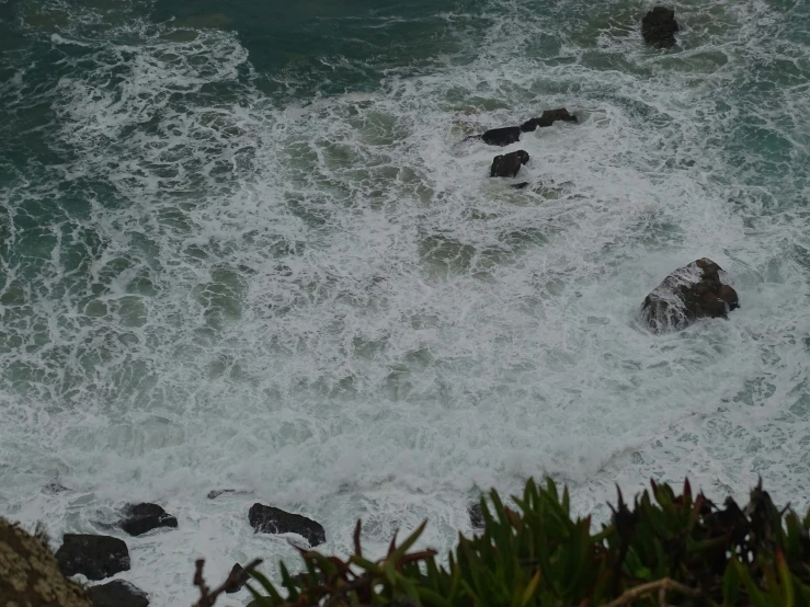 an image of water splashing into the sea with rocks