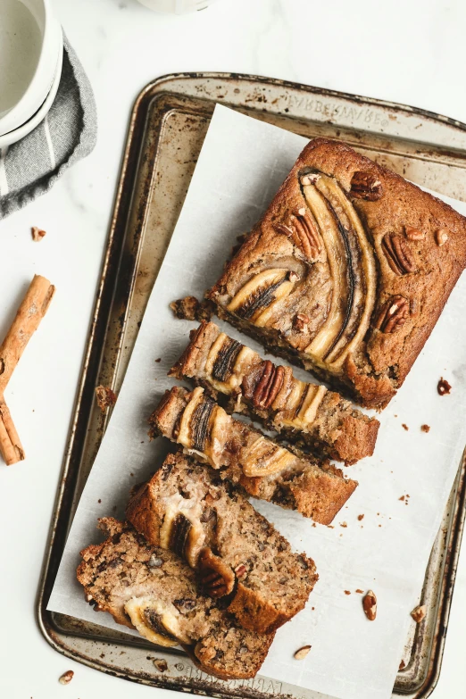 sliced banana bread sitting on a tray next to a cup