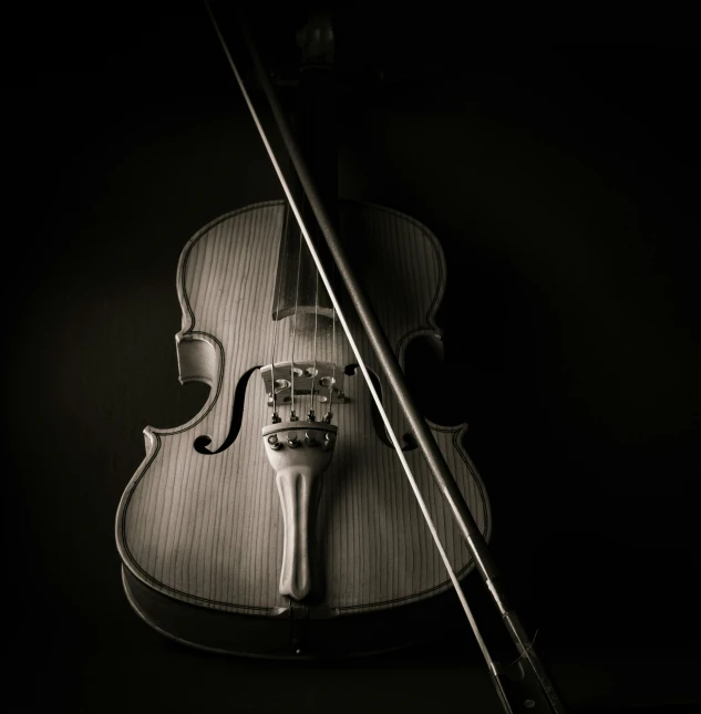 a violin with its fiddle and bow on a black background