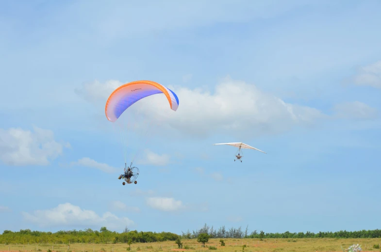 two people in the middle of a field with some kites flying