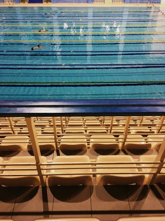 empty stadium chairs are sitting near the pool