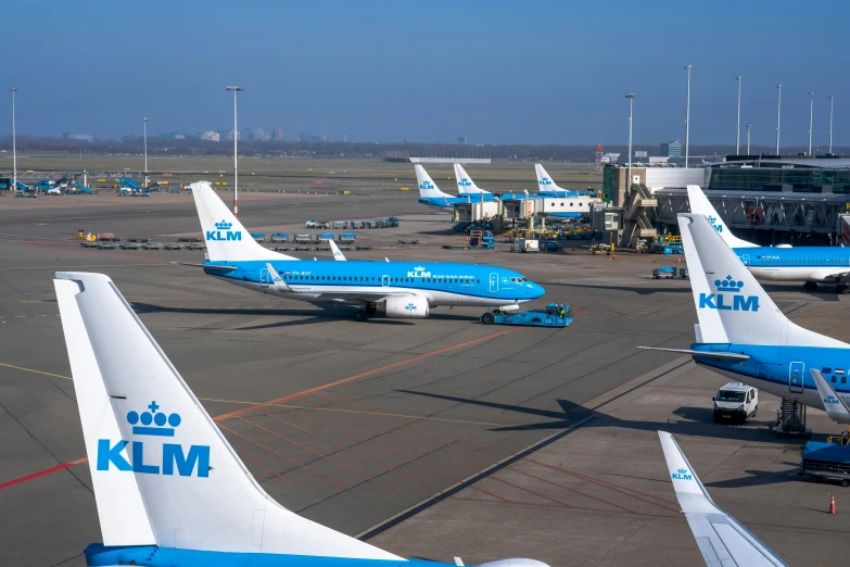 three blue and white jetliners are parked at the airport