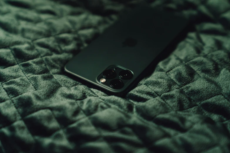 a black phone sitting on a bed