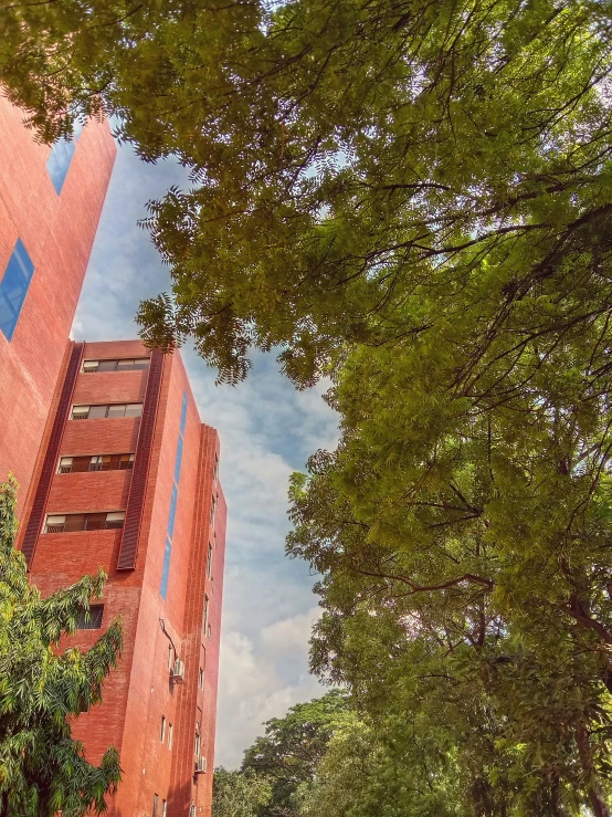 a red brick building near trees and plants