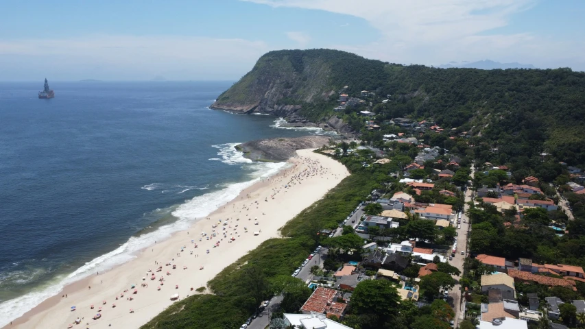 an aerial view of a crowded beach and body of water