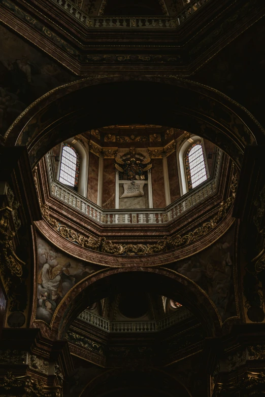 the ceiling of a building that has a clock at it