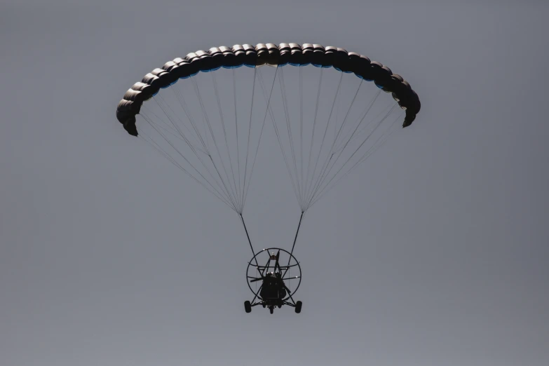 people riding on the back of a parachute in the air