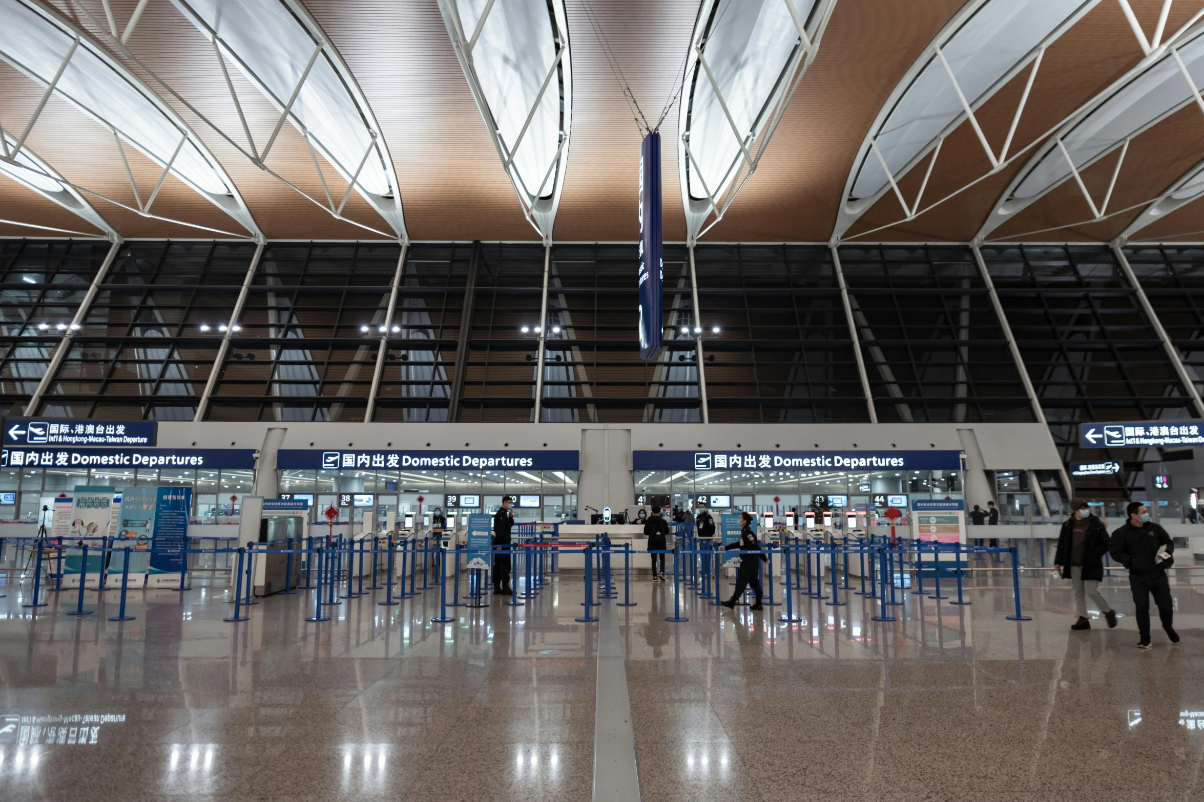 several people are in an empty airport with luggage