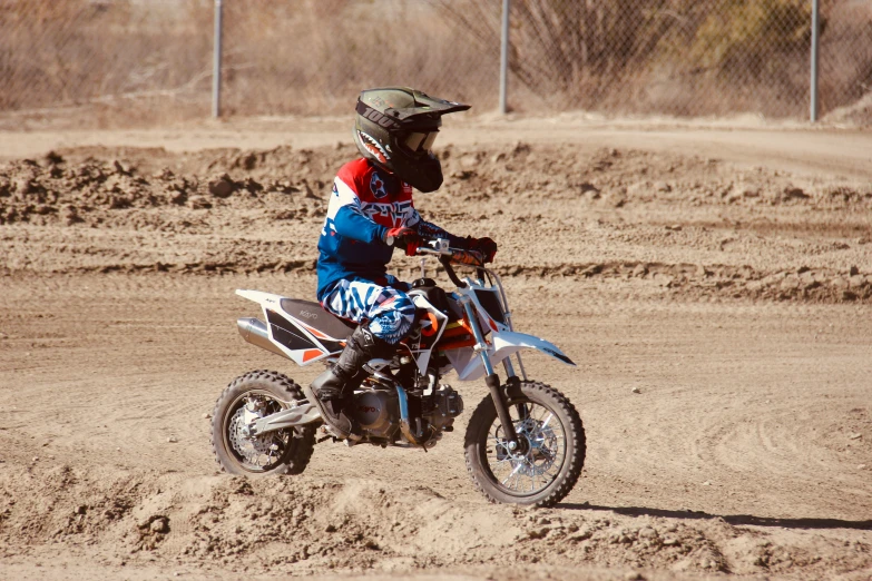 a person on a dirt bike on sand