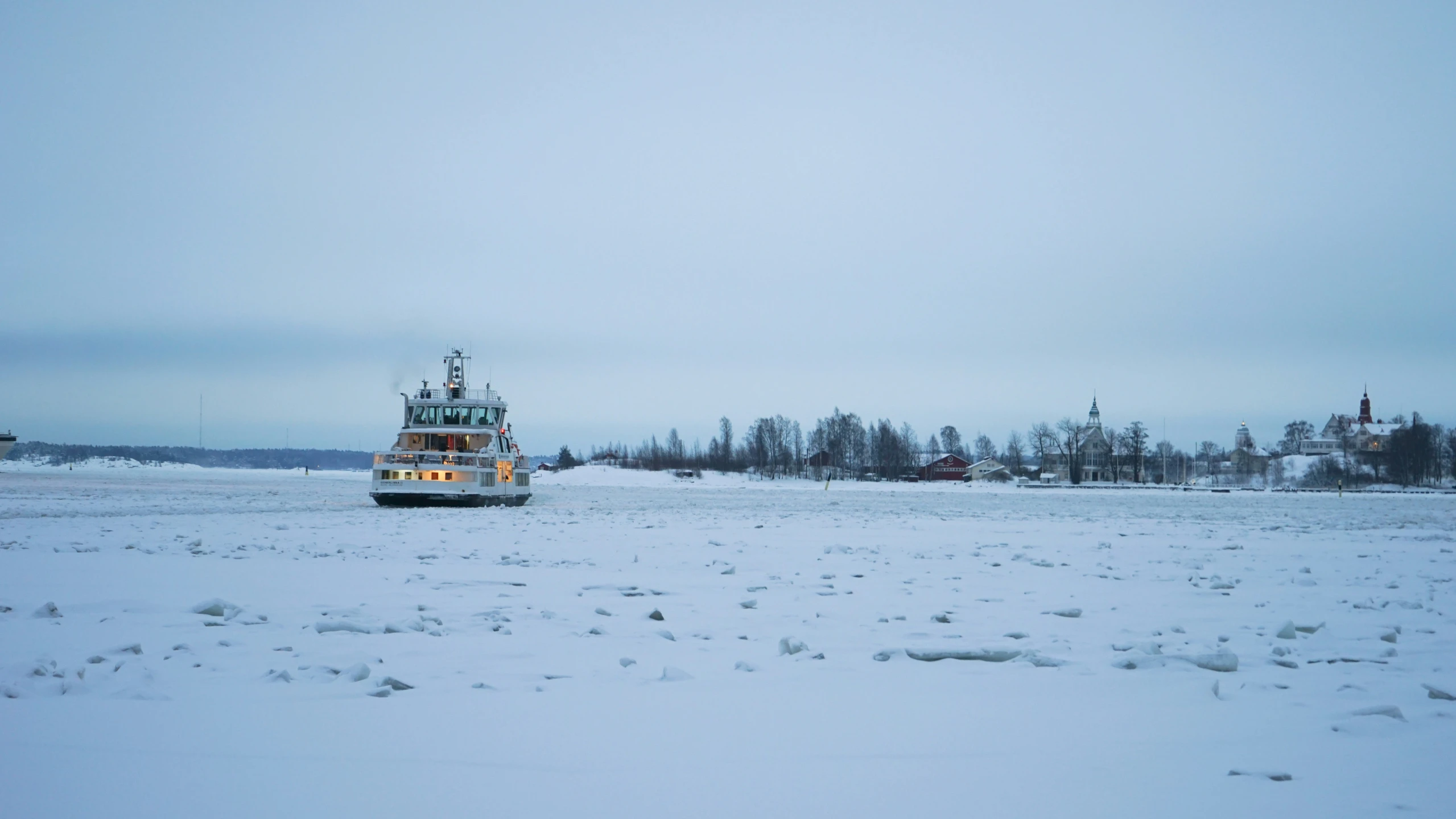 a large ship is on the sea in snow