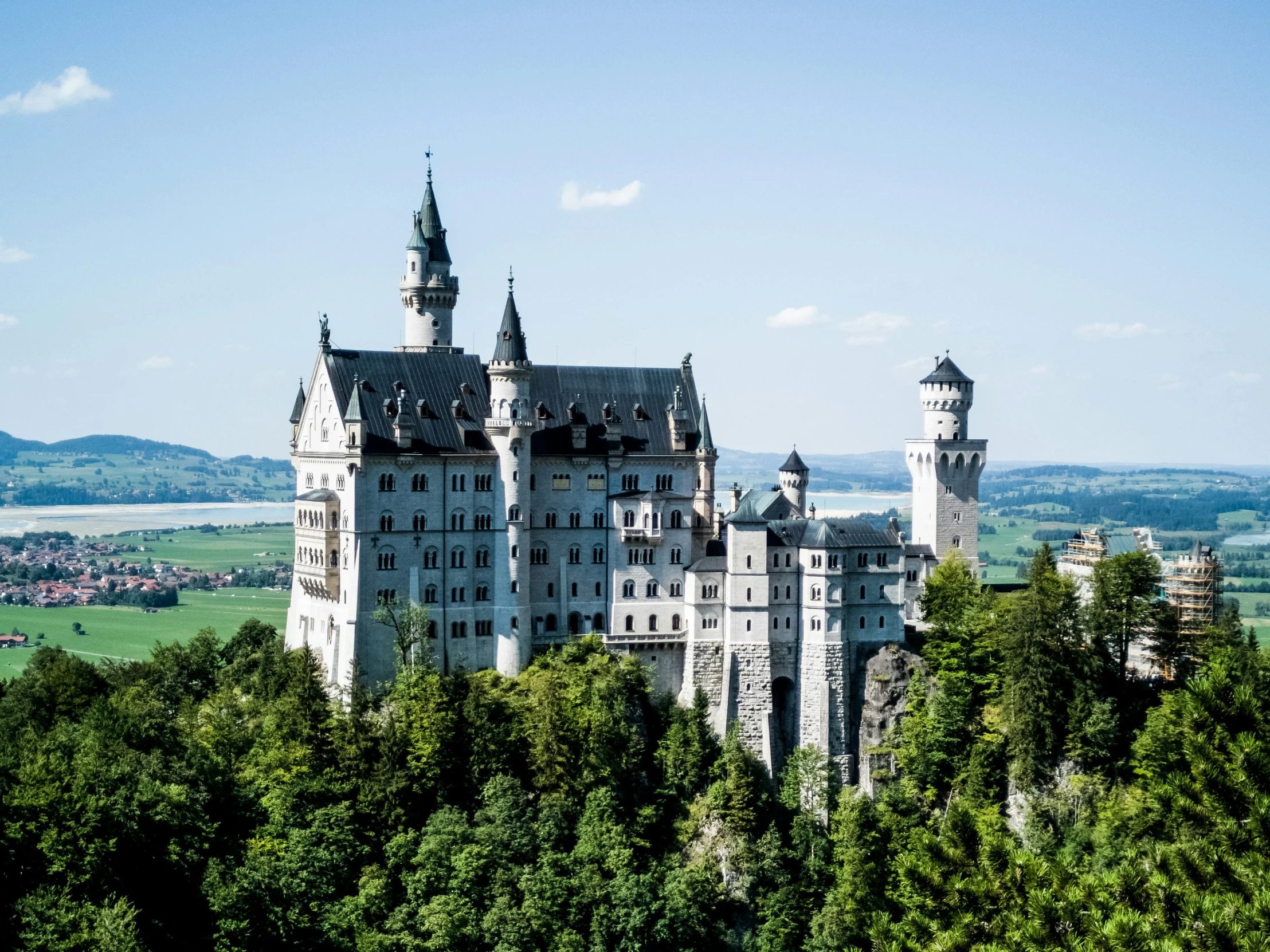 an old castle sits atop a hill surrounded by trees