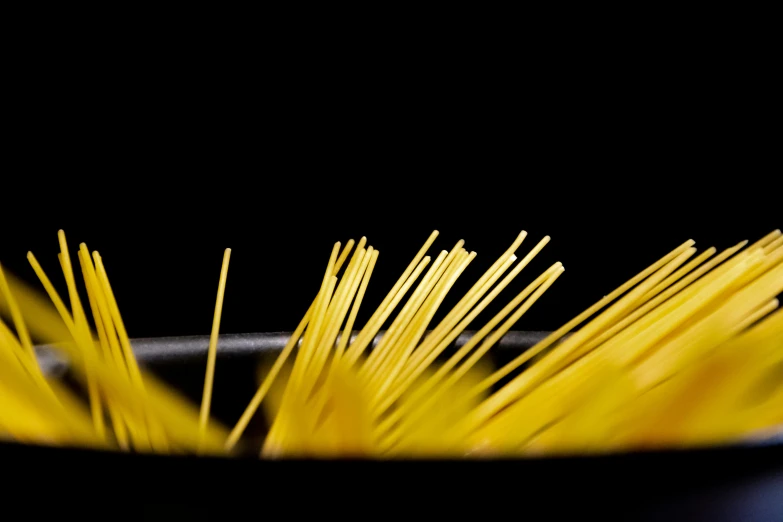 closeup of yellow pasta in black bowl