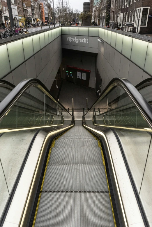 an escalator leading to the train station in a city